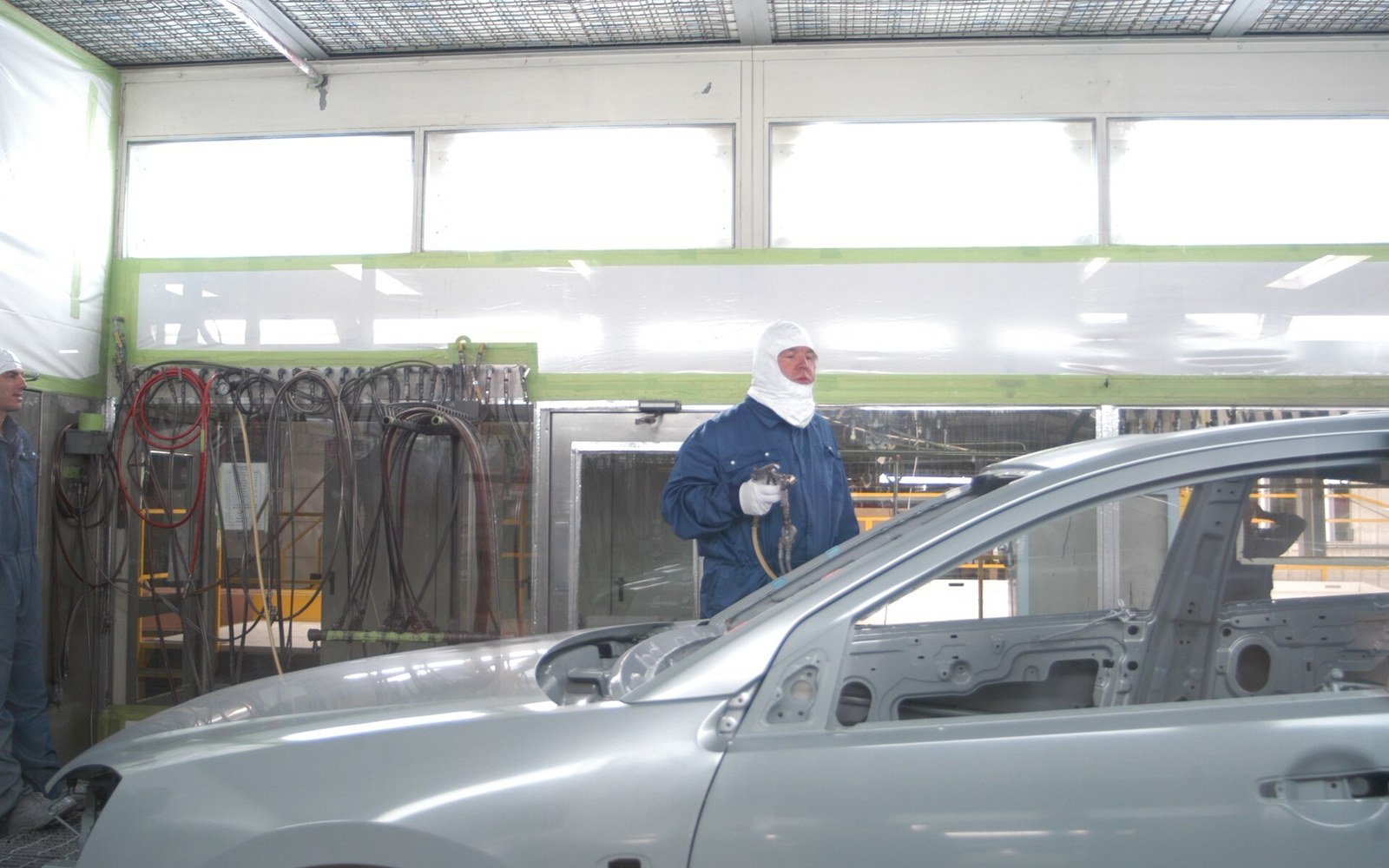 A bare body shell inside a spray booth under even light